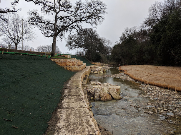limestone blocks are being placed along the side of a creek