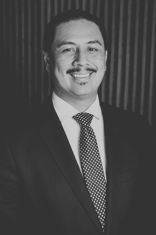 a black and white photo of Jorge Morales, director of the Watershed Protection Department, in a suit and tie