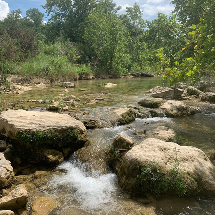 Barton Creek flowing through a wooded area with rocks and trees